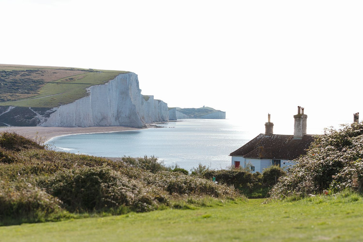 The white chalk cliffs of the Seven Sisters beyond the coastguard cottages at Cuckmere Haven, East Sussex