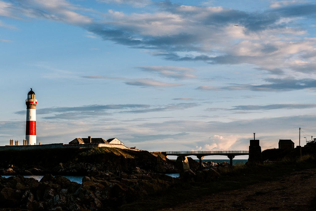Red and white lighthouse on a rocky headland above the North Sea, Aberdeenshire